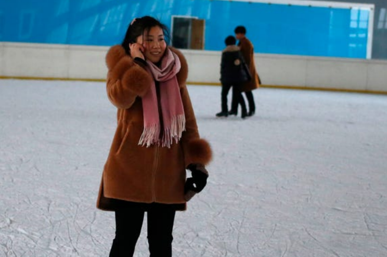 فتاة في كوريا الشمالية تستخدم الهاتف وهي تتزلج على الجليد 10 ديسمبر 2018